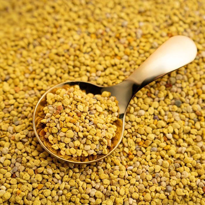 Nature’s Element – Bee Pollen in Spoon Nature’s Element bee pollen granules in golden spoon – organic energy superfood