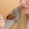 Nature’s Element – Bee Bread Spoon Close-Up Person holding golden spoon with Nature’s Element bee bread – natural immune support supplement