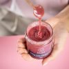 Nature’s Element – Blackcurrant Honey Lifestyle Person holding open jar of Nature’s Element blackcurrant honey with dipper – natural fruit honey