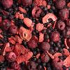 Overhead view of mixed freeze-dried berries showing strawberry slices, whole blueberries and cherries with natural texture